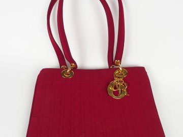 Christian DIOR. Sac en toile bordeau, breloques dorées