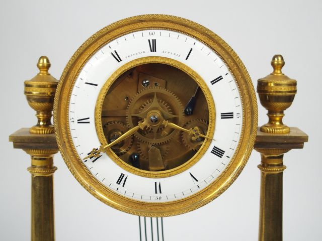 Pendule portique squelette XIXème en bronze doré, le cadran marqué Mes