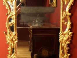 Miroir à parecloses Louis XV en bois sculpté et doré, à décor de rince