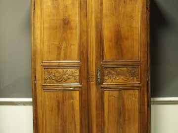 Armoire début XIX ème en merisier mouluré et sculpté, à décor d'instru