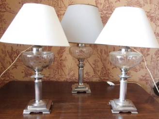 Vente aux enchères Trois lampes de chevet en métal argenté	, avec leurs réservoirs en cri
