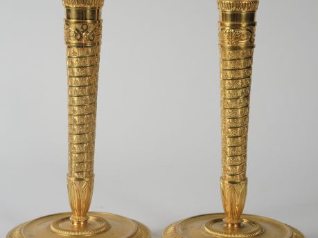 Paire de bougeoirs de style Empire en bronze doré et ciselé à décor de