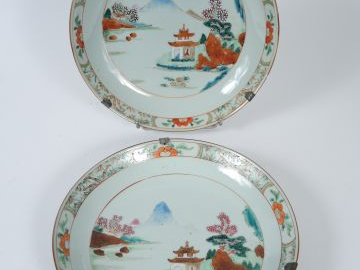 Paire d’assiettes à décor de pagodes sur fond de paysage lacustre.  Ch