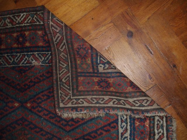 Tapis d'Orient en laine, décor de motifs géométriques rouge vert et bl