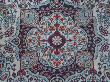 Tapis en laine décor rouge et bleu sur fond crème