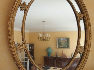 Miroir médaillon de style rocaille en bois et stuc doré