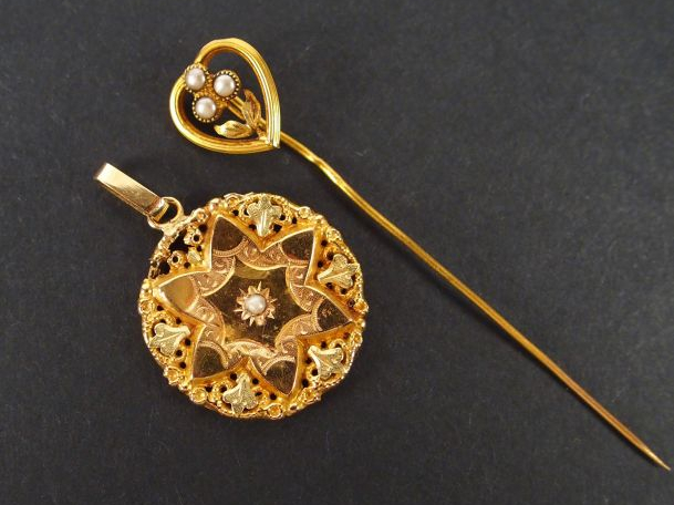 Epingle à chapeau en or jaune à décor de cœur et de fleur. On y joint 