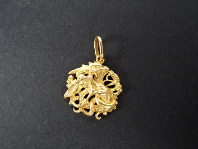 Pendentif rond en  jaune à décor de chimère en relief. Poids: 5,6gr