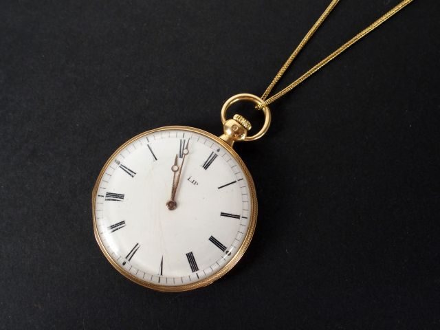 LIP. Montre de gousset et sa chaîne en or jaune, cadran émail. Poids t