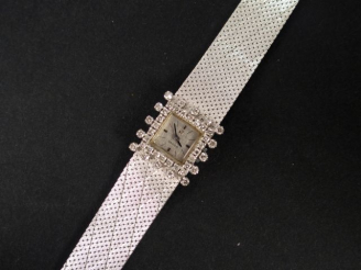 Vente aux enchères OMEGA. Montre de dame, bracelet semi-rigide en or blanc, boitier carré