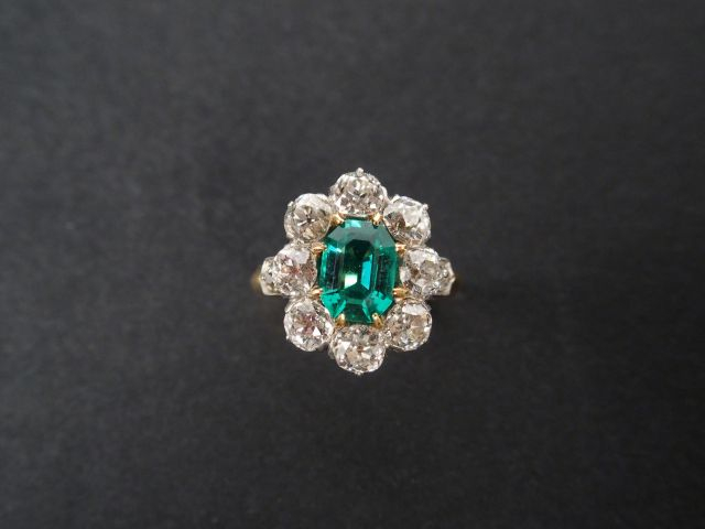 Bague marguerite monture or jaune, ornée en son centre d'une émeraude 