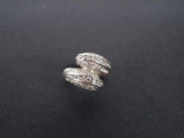 Bague monture or blanc, ornée de 2 volutes entrelacées pavées de brill
