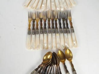 Vente aux enchères Suite de couverts à dessert en métal doré et manche en nacre.