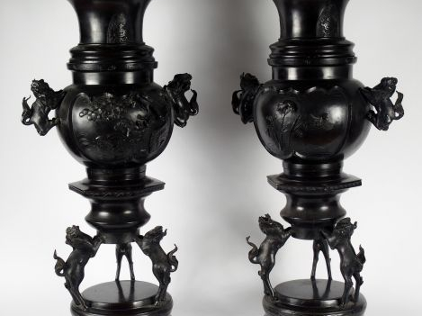 Paire de vases en bronze à patine brune sur leurs socles tripodes, à d