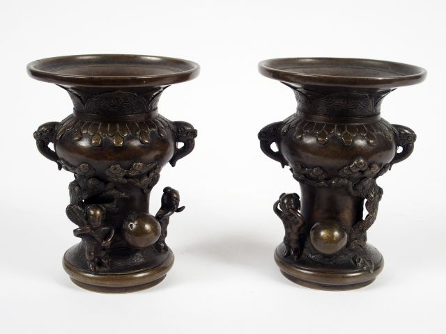 Paire de petits vases en bronze à patine brune, sur un haut pied entou