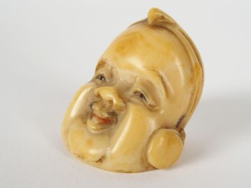 Netsuké en ivoire d’éléphant sculpté figurant un visage de Daikoku, un