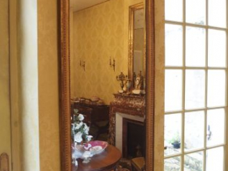 Vente aux enchères Miroir de style Louis XVI en bois sculpté et doré, à décor de perles e