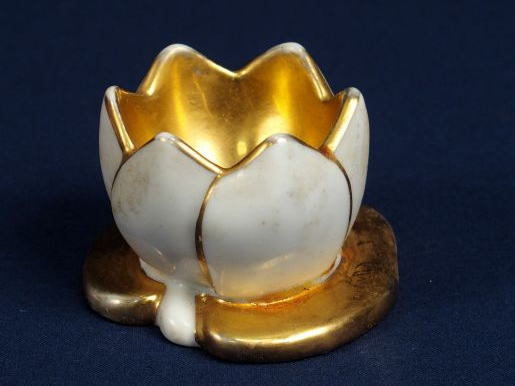 ROBJ. Coquetier en porcelaine blanche et dorée. Signé.