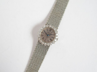 Vente aux enchères LONGINES. Montre dame, boitier rond entourage de brillants de 5 centiè