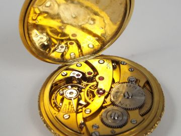 UNIC. Montre de gousset en or jaune décor gravé d'émail noir, chronomè