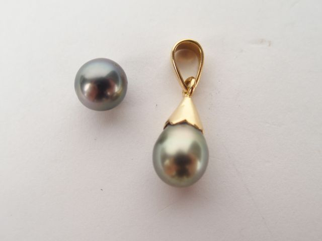 Perle grise baroque montée en pendentif, bélière en or jaune. On y joi