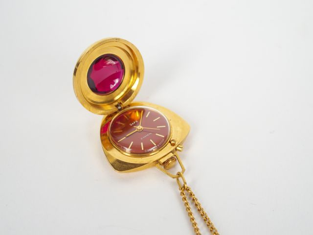 Pendentif et montre cage en plaqué or, décor de rubis synthétique.