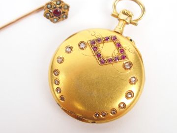 Petite montre de col en or jaune, décor de roses et de rubis. On y joi
