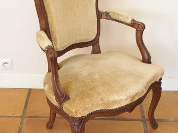 Cabriolet Louis XV en bois naturel, mouluré et sculpté, à décor de fle