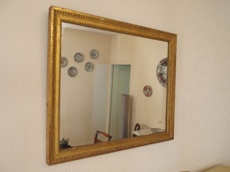 Vente aux enchères Glace Louis XVI en bois sculpté et doré, à décor de perles et de rais-