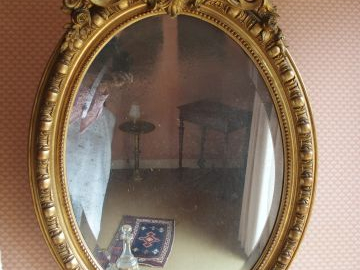 Miroir médaillon en bois et stuc doré, à décor de rocailles et de fleu