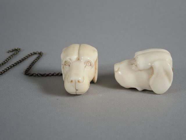 Deux sujets en ivoire sculpté 'têtes de chien'