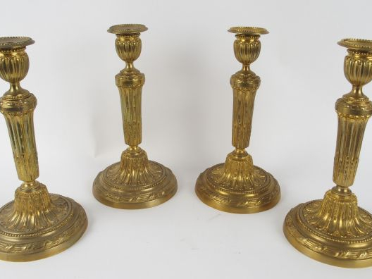 Suite de quatre bougeoirs Louis XVI en bronze ciselé et doré, piédouch