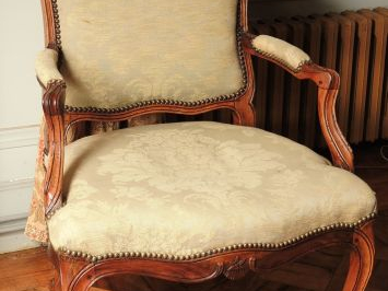 Fauteuil à dossier plat Louis XV en noyer mouluré et sculpté à décor d
