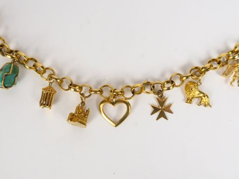 Bracelet en or, orné de 7 breloques, dont une turquoise. Deux breloque