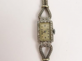 Vente aux enchères Montre de dame en or gris pavée de brillants, cadran à chiffres arabes