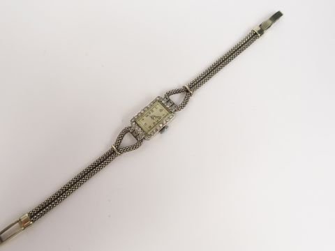 Montre de dame en or gris pavée de brillants, cadran à chiffres arabes