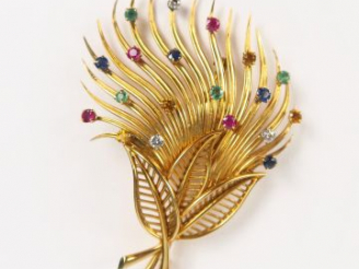 Vente aux enchères Broche feuillage en or jaune ornée de petits rubis, saphirs, émeraudes
