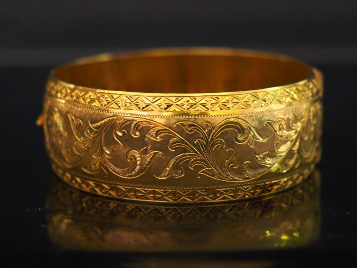 Large bracelet jonc en or jaune, à décor gravé de rinceaux feuillagés 