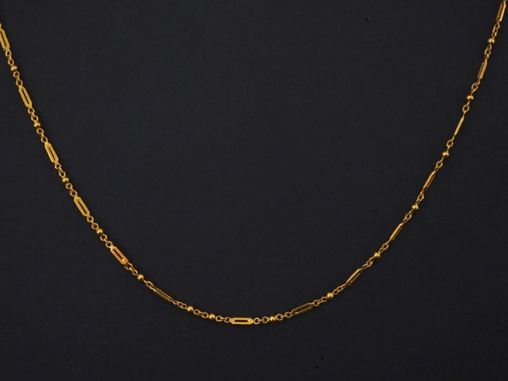 Collier souple en or jaune, à décor de petites boules et maillons ajou