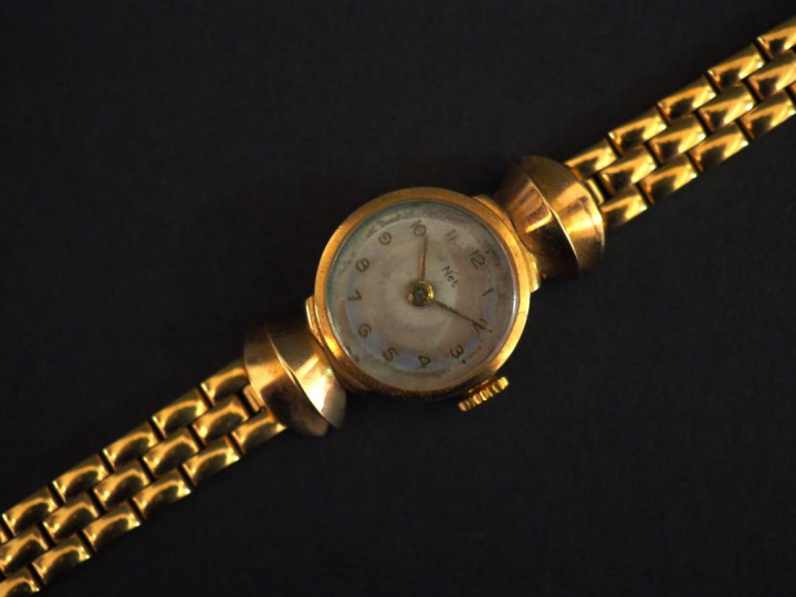 Montre de dame NET, boitier or, bracelet métal.  Poids tel : 23 g   