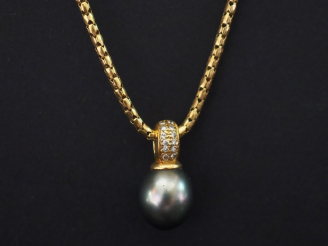 Vente aux enchères Collier en or, maille tube articulé et pendentif en perle gris de Tahi