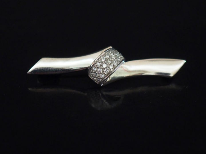 Broche de forme ruban en or blanc et pavage de diamants. Poids tel : 5