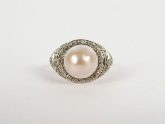 Vente aux enchères Bague monture platine, pavée de roses et surmontée d'une perle mabée. 