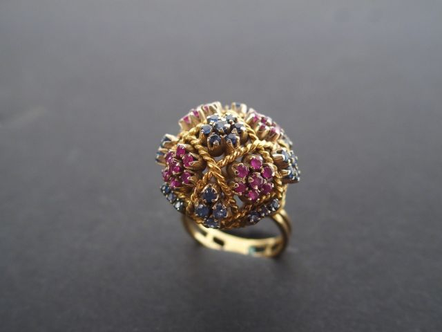 Bague dôme monture or jaune ajourée, rehaussée de saphirs et rubis.  T