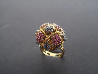 Vente aux enchères Bague dôme monture or jaune ajourée, rehaussée de saphirs et rubis.  T
