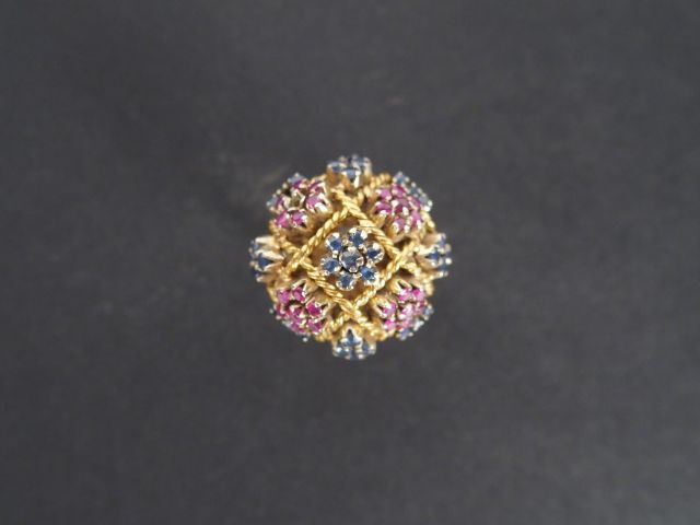 Bague dôme monture or jaune ajourée, rehaussée de saphirs et rubis.  T