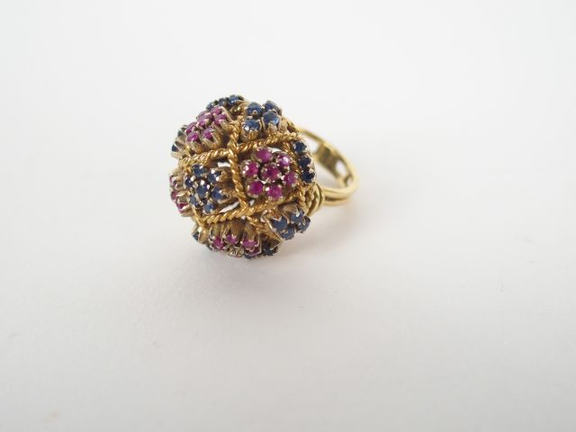 Bague dôme monture or jaune ajourée, rehaussée de saphirs et rubis.  T