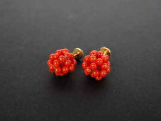 Vente aux enchères Paire de perce-oreilles ronde en perles de corail.