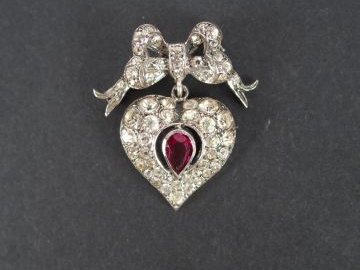 CHRISTIAN DIOR. Broche monture argent en forme de cœur enrubanné pavée