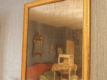 Miroir de style Louis XVI en bois et stuc doré à décor de raies de cœu